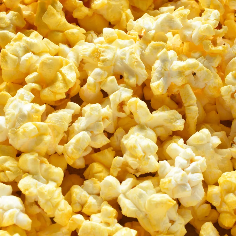 Freshly popped golden and white popcorn kernels in bulk, ideal for wholesale food suppliers and commercial foodservice distribution.